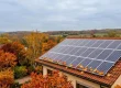 Panneaux solaires sur un toit en automne avec un graphique de production saisonnière normale et des feuilles mortes.